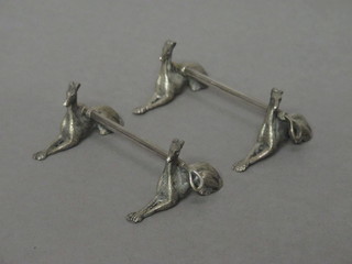A pair of silver plated knife rests in the form of hunting crops  and reclining grey hounds