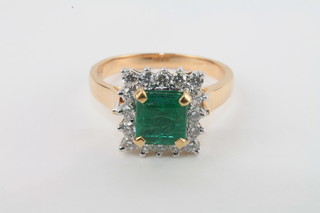 A lady's yellow gold dress ring set a square cut emerald  surrounded by diamonds