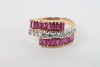 A lady's yellow gold dress ring set a row of diamonds supported  by baguette cut rubies