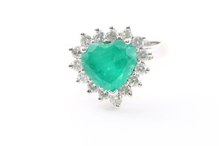 A lady's 18ct white gold dress ring set a large heart shaped  emerald supported by diamonds