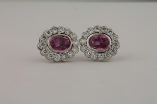 A pair of 18ct white gold earrings set oval cut pink sapphires surrounded by diamonds, approx 1.90/1ct