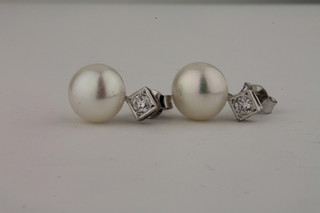A pair of diamond and pearl ear studs