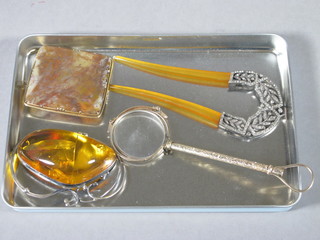 An Edwardian silver plated hair comb, a pair of lorgnettes, a  large amber brooch and an agate brooch