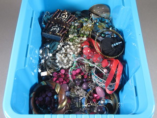 A blue crate containing costume jewellery