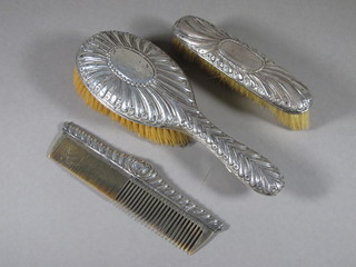 An embossed silver backed clothes brush, ditto hair brush and comb