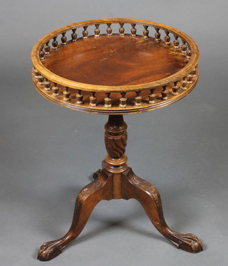 A Georgian style circular mahogany wine table with gallery, raised on pillar and tripod supports 18"
