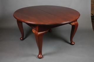 A mahogany oval extending dining table with 3 extra leaves, raised on cabriole supports
