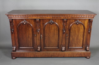 A Victorian mahogany sideboard enclosed by 3 arch panelled  doors raised on bun feet 67"