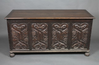 A Victorian carved oak coffer of panel construction raised on bun  feet 56"