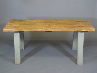 A rectangular rustic pine kitchen table, the top of plank construction raised on outswept supports 65"