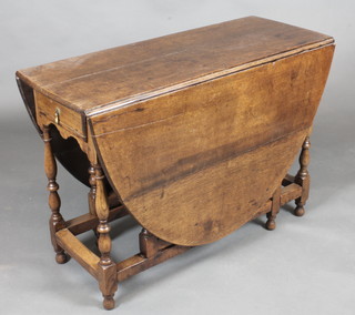 An 18th Century oak drop flap gateleg dining table raised on  turned and block supports 40"