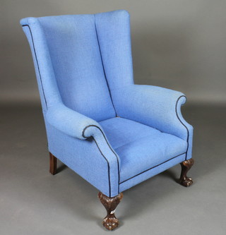 A mahogany winged armchair upholstered in blue material raised  on cabriole supports
