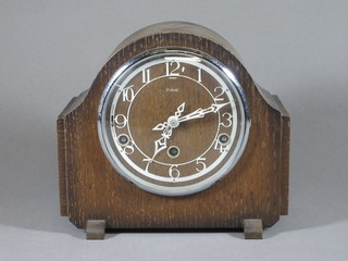 An Enfield chiming mantel clock with Arabic numerals contained  in an oak arch shaped case