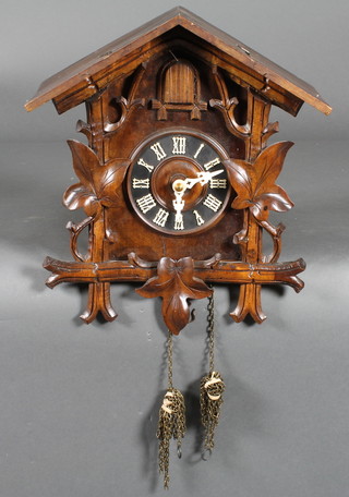 A 19th/20th Century Continental cuckoo clock contained in a  carved walnut case