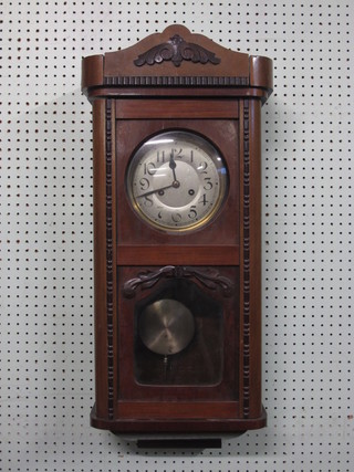 A striking wall clock with silvered dial contained in a walnut case