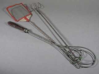 A 1930's metal fly swat, a carpet beater and a metal toasting fork