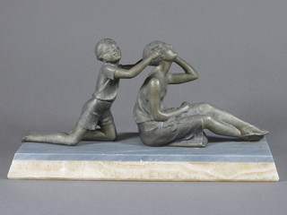 A French Art Deco spelter figure of a seated mother and child, raised on a rectangular 2 colour marble base 15 1/2", missing a  section of marble to the side,