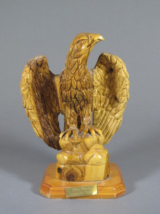 A carved olive wood figure of a seated eagle with wings outstretched, the base marked Nazareth 2000, 11"