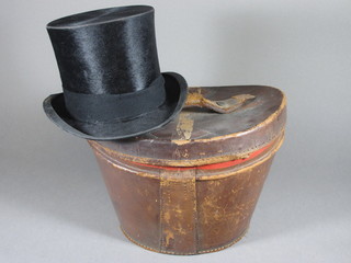 A gentleman's black top hat by Henry Heath, contained in a  leather hat box