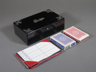 A rectangular ebony bridge card case with silver mounts containing packs of cards and various score pads