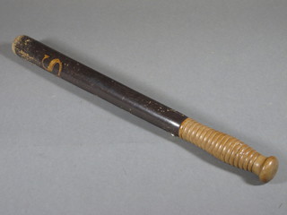 A turned wooden truncheon marked CS