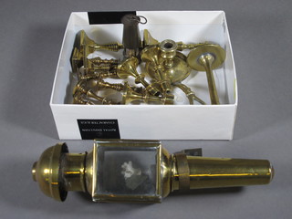 A miniature brass coaching lamp and a collection of miniature brass candlesticks