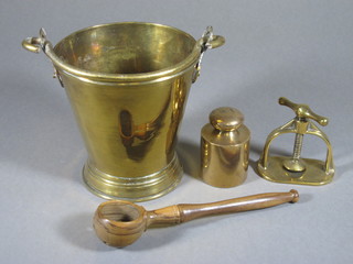 A brass bell 5 1/2", a brass 1 kg weight, a brass press and an olive wood ladle