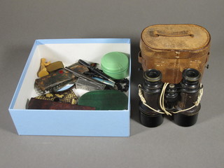 A pair of binoculars in a leather case and a collection of curios