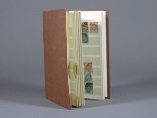 A brown stock book of Victorian and later stamps
