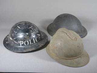 A WWI French Adrian steel helmet - no liner, together with a  British steel helmet - no liner, and 1 other marked Police with  liner