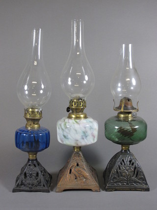 3 Victorian coloured glass oil lamp reservoirs raised on pierced  iron bases