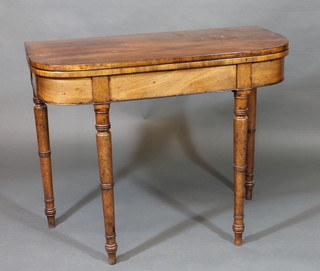 A Georgian mahogany D shaped card table raised on turned  supports 36"