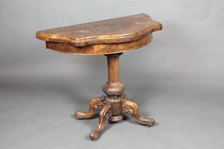 A Victorian walnut card table of serpentine outline, raised on turned tripod supports 36"