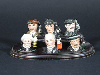 A set of 6 tiny Royal Doulton limited edition Sherlock Holmes character jugs - Mrs Hudson, Professor Moriarty, Jefferson  Hope, Sherlock Holmes, Dr Watson and Inspector Lastrade, base   marked D7015 number 754 1 1/2", complete with wooden stand   ILLUSTRATED