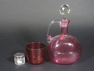 A cranberry glass ewer with clear glass handle 8", a cranberry  glass tumbler 3" and a cylindrical glass pin jar with silver lid