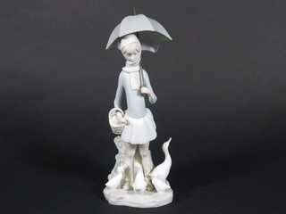 A Lladro figure of a standing girl with umbrella and geese 11"