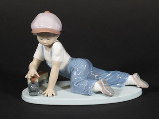 A Lladro figure of a crouching boy with train, base marked 7619 5"
