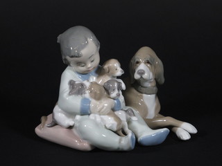 A Lladro group of seated boy with dog and puppies 5"