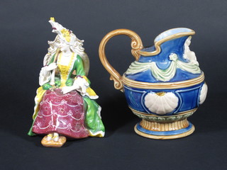 A Majolica style jug decorated a cherub raised on a circular spreading foot 6" and a Continental porcelain figure of a seated  lady 7"