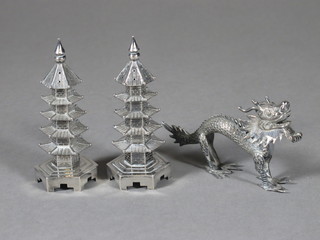 A pair of Oriental white metal pepperettes in the form of Pagodas  3" together with an Oriental menu/place name holder in the form  of a Dog of Fo