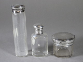 A circular dressing table jar with silver, a matching pin jar - cracked, Birmingham 1919 and 1920 and 1 other faceted glass  dressing table jar with lid
