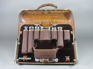An excellent Victorian 21 piece travelling vanity set comprising 6 cut glass bottles with silver mounts, London 1887, a double  ended scent bottle with silver mounts, silver lid, polished steel  folding carriage key, leather box with hinged lid, pair of silver  hair backed clothes brushes, ivory letter opener, ivory shoe horn,  pair of ivory glove stretchers, mother of pearl handled button  hook, bodkin, nail file and scent bottle corkscrew, a vesta case,  card case, address book and blotter all contained in a crocodile  case  ILLUSTRATED