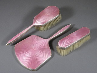A 3 piece silver and pink enamelled back dressing table set comprising hand mirror, hair brush and clothes brush  Birmingham 1931 and 1934