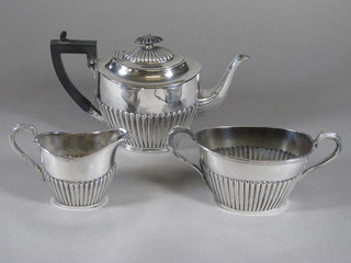 An oval Britannia metal 3 piece tea service with demi-reeded  decoration comprising teapot, twin handled sugar bowl and milk  jug