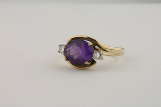 A 9ct gold dress ring set an oval cut amethyst supported by 2  diamonds