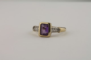 A lady's gold dress ring set a rectangular cut amethyst supported  by diamonds