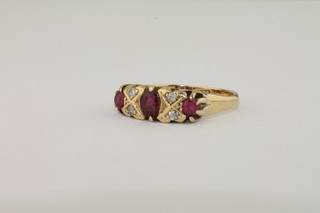 A lady's 18ct yellow gold dress ring set 3 oval cut rubies supported by diamonds