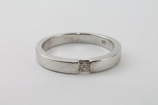 An 18ct white gold band set a solitaire diamond