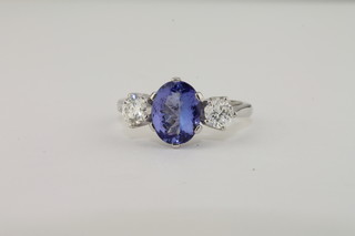 A lady's 18ct white gold dress ring set an oval tanzanite  supported by diamonds, approx 2.0/0.55ct