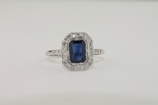 A lady's 18ct white gold dress ring set a rectangular sapphires surrounded by diamonds